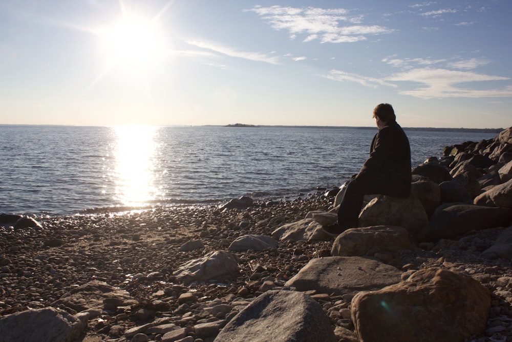 man sitting on brown stone