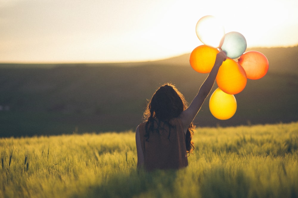 Unbekannte Person hält Luftballons im Freien