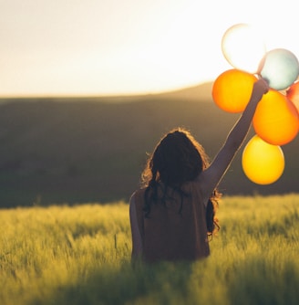 unknown person holding balloons outdoors