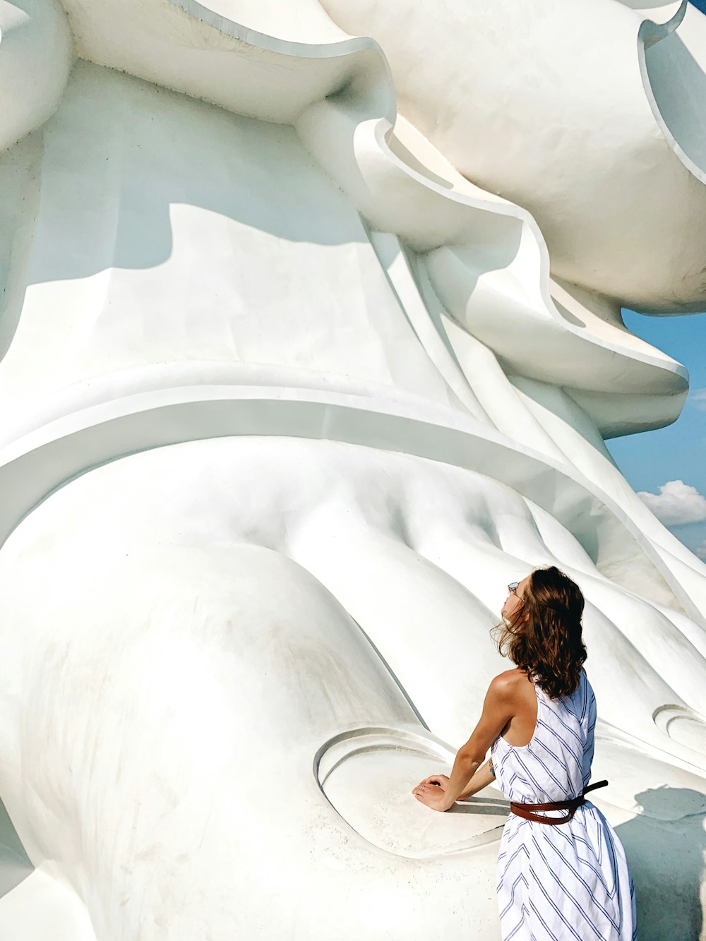 donna in piedi accanto al monumento del piede umano durante il giorno