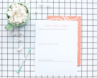 white printer paper near green ceramic mug