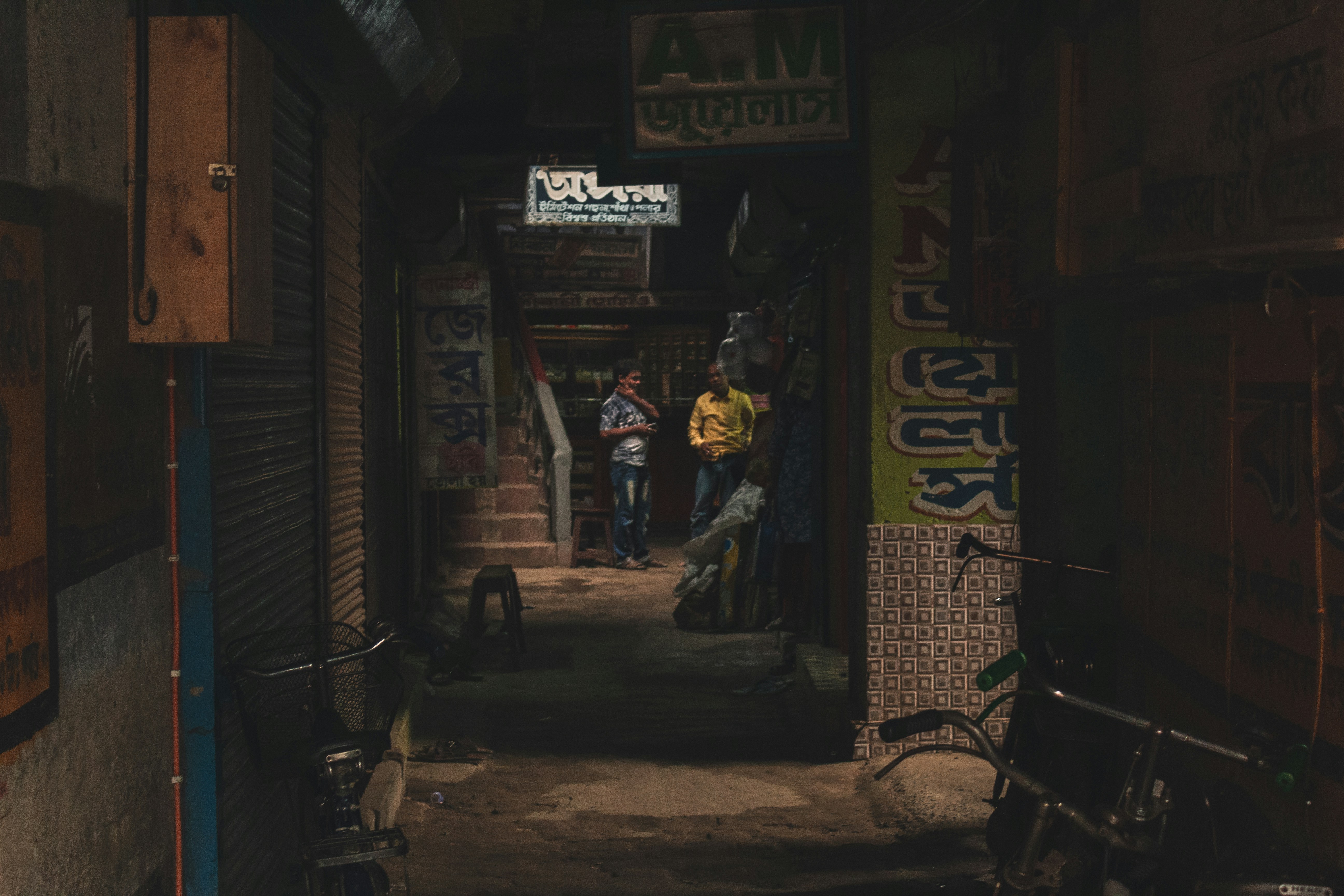 A close-up shot of a young man's hand counting a wad of cash, with blurred background hinting at a Goa street or shack.