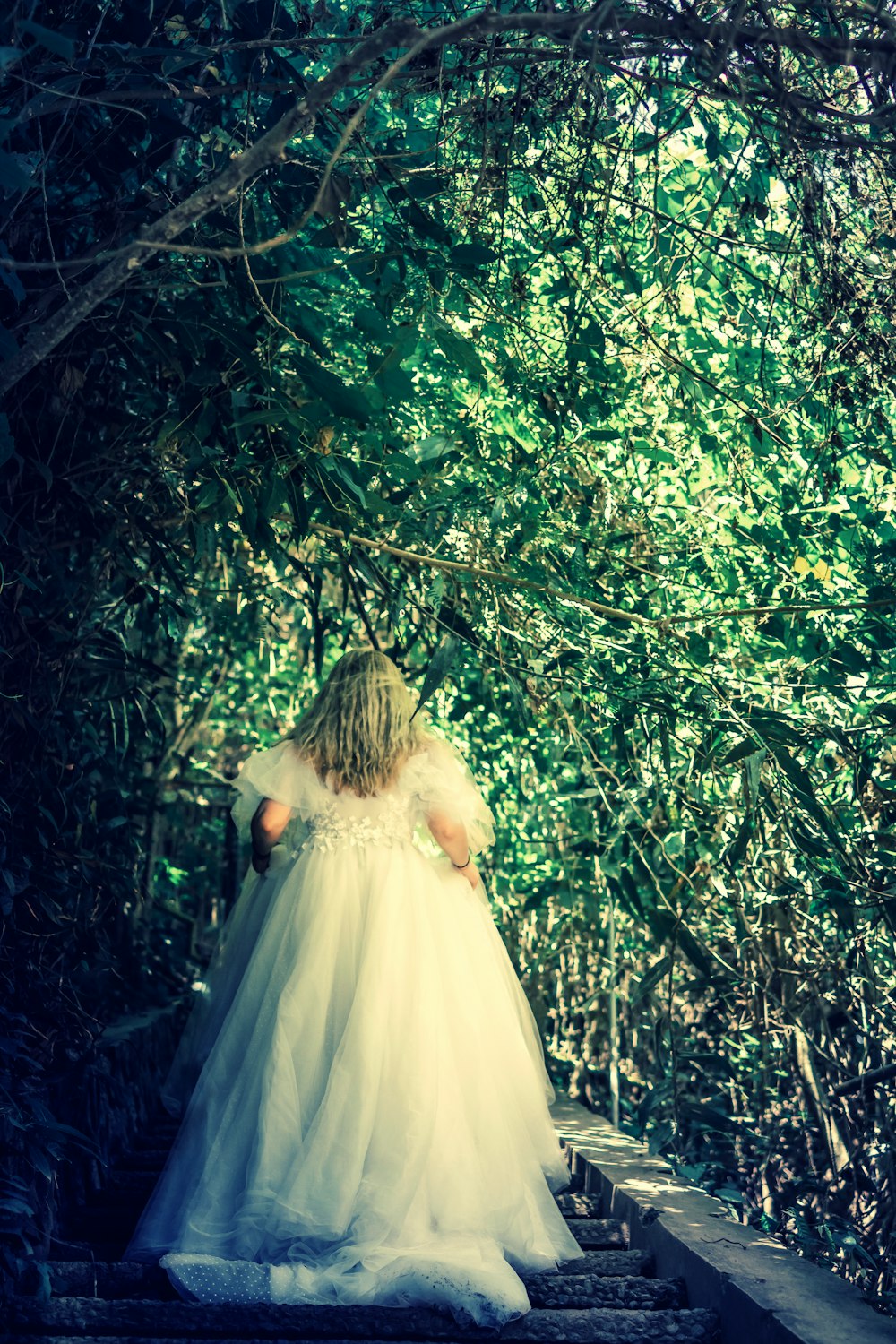 woman in white wedding dress under tree
