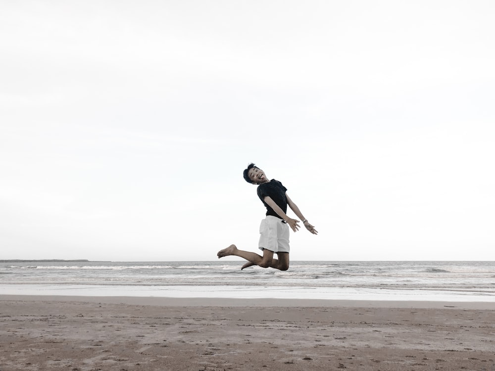 boy jumping on shore