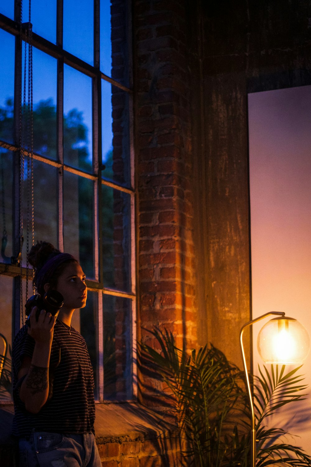 woman standing near window holding camera