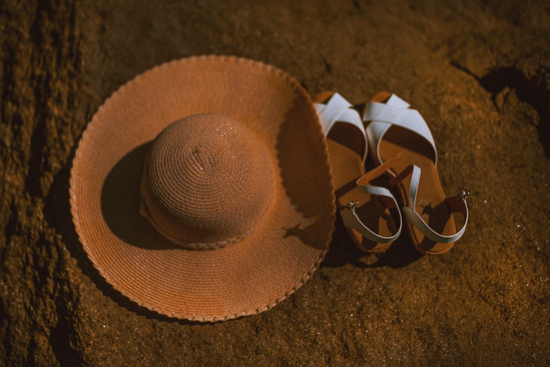 brown sun hat beside sandals