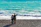 A couple relaxing on a sunny beach with turquoise water.