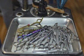 Set of shiny, sharp hair-cutting scissors resting on a textured salon countertop.