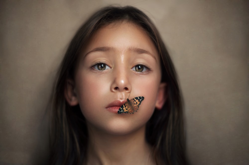 girl with butterfly perched on her lips