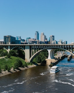 a boat traveling down a river under a bridge