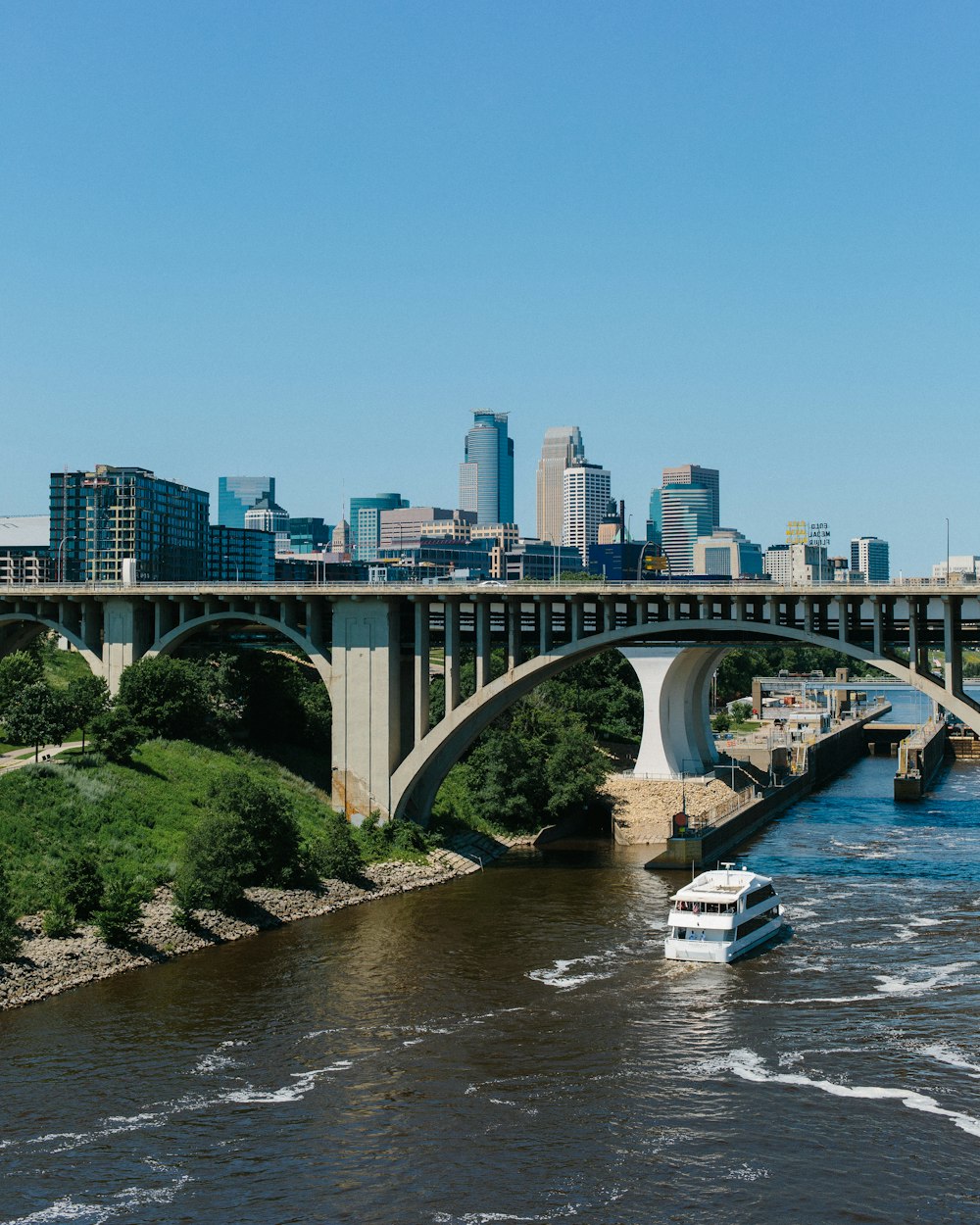 a boat traveling down a river under a bridge