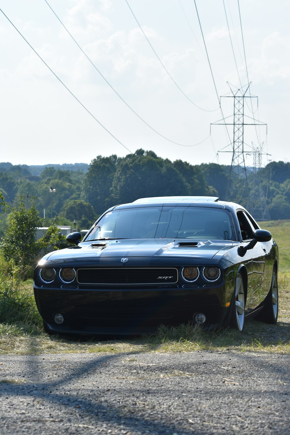 black coupe parked near grass field during daytime