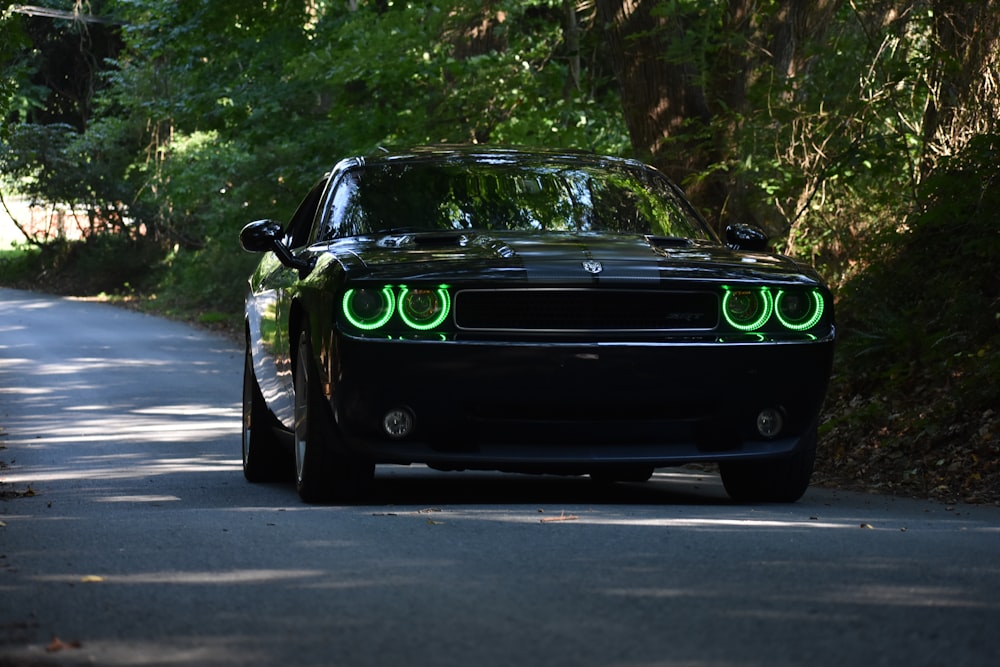 black Dodge Challenger parked beside tree