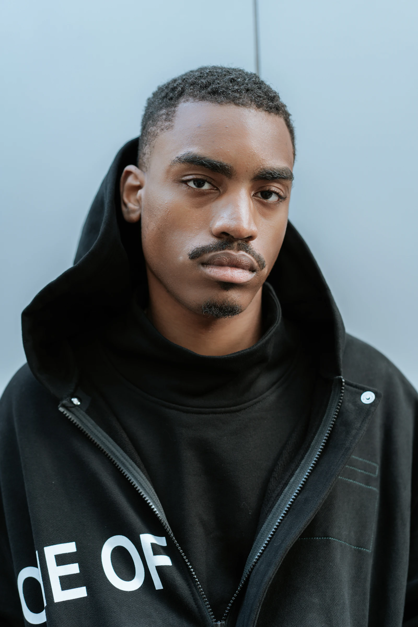 A man wearing a simple hoodie, suggesting everyday spiritual streetwear style