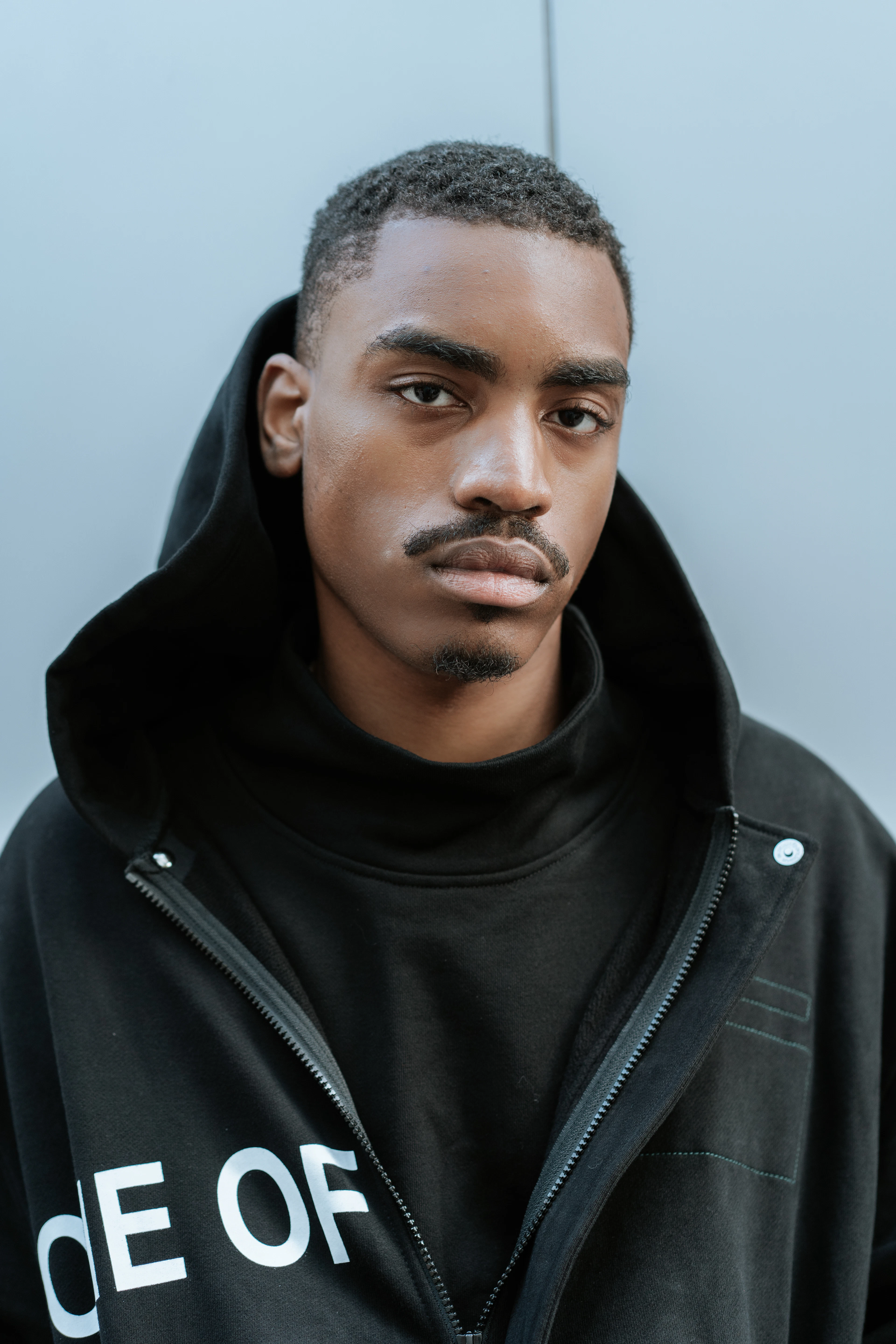 Person wearing a black zip-up hoodie outdoors