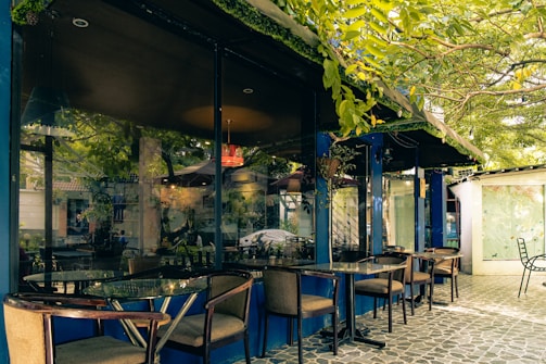 A serene outdoor café scene in Accra, with subtle gold and orange accents in the decor.