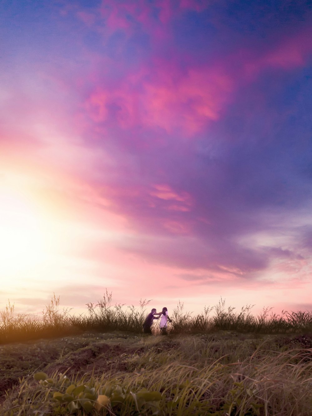 man and woman on grass field under cloudy sky during daytime