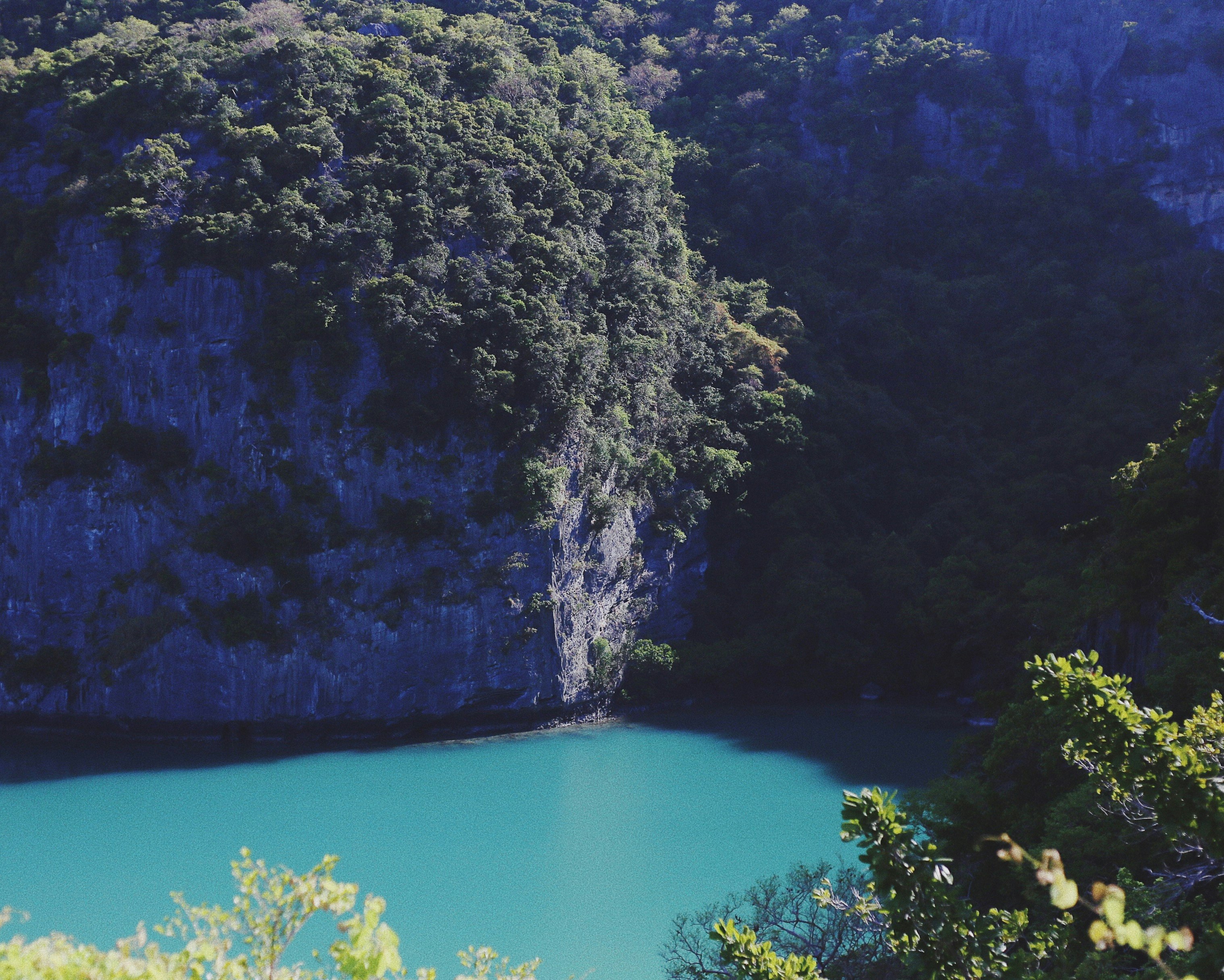 aerial photography of body of water beside mountain during daytime