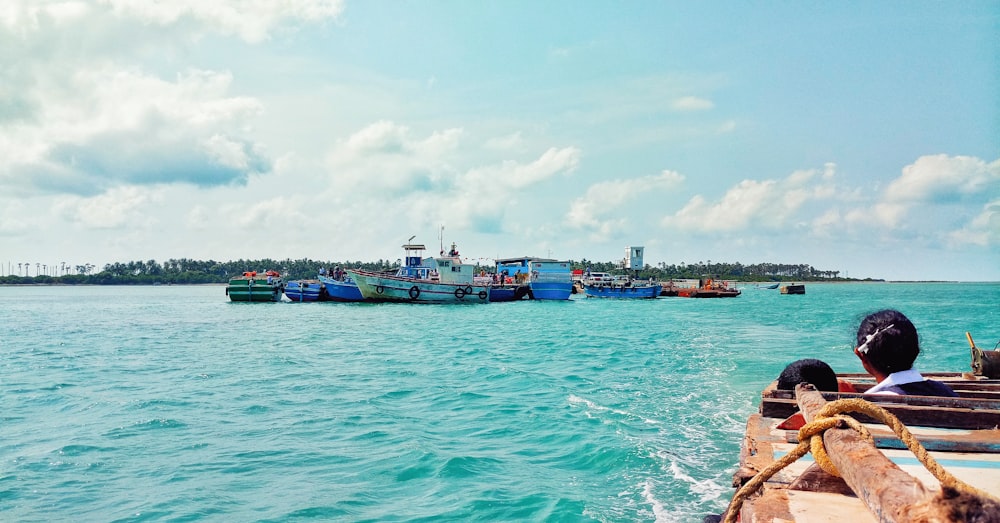 brown boat on body of water across assorted-colored boats