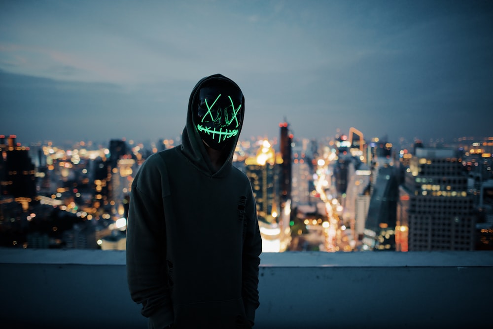 silhouette photo of person wearing lighted mask