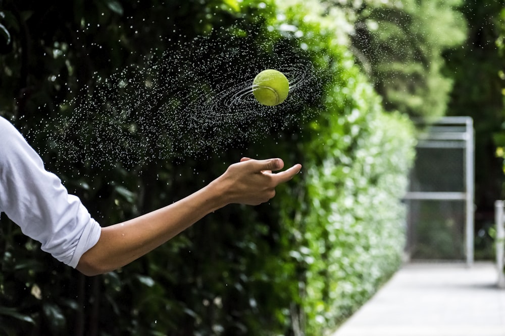 person throwing tennis ball
