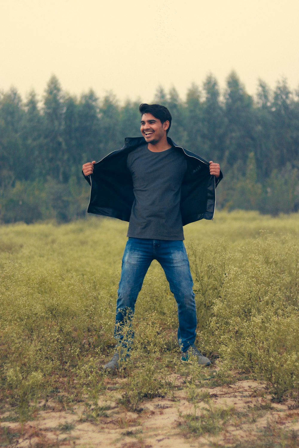 man wearing black crew-neck shirt and blue denim jeans