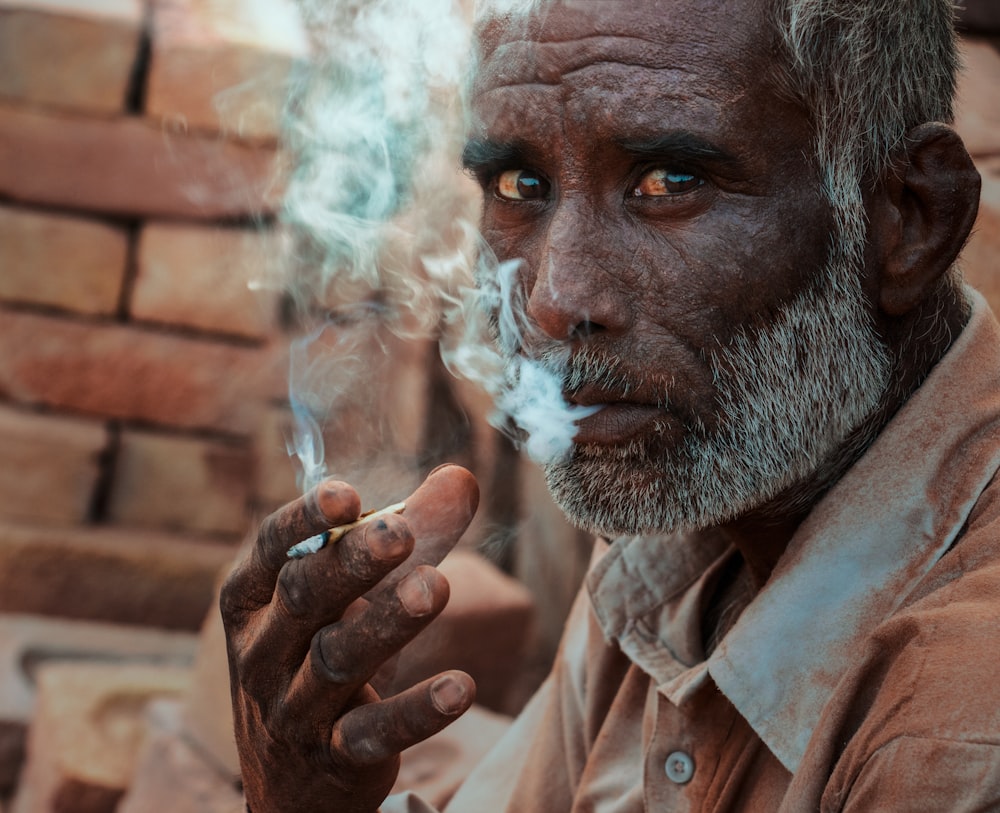 man in brown dress shirt smoking