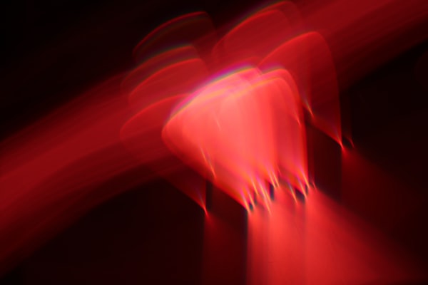 a blurry image of an orange object vibrating against a reddish streak