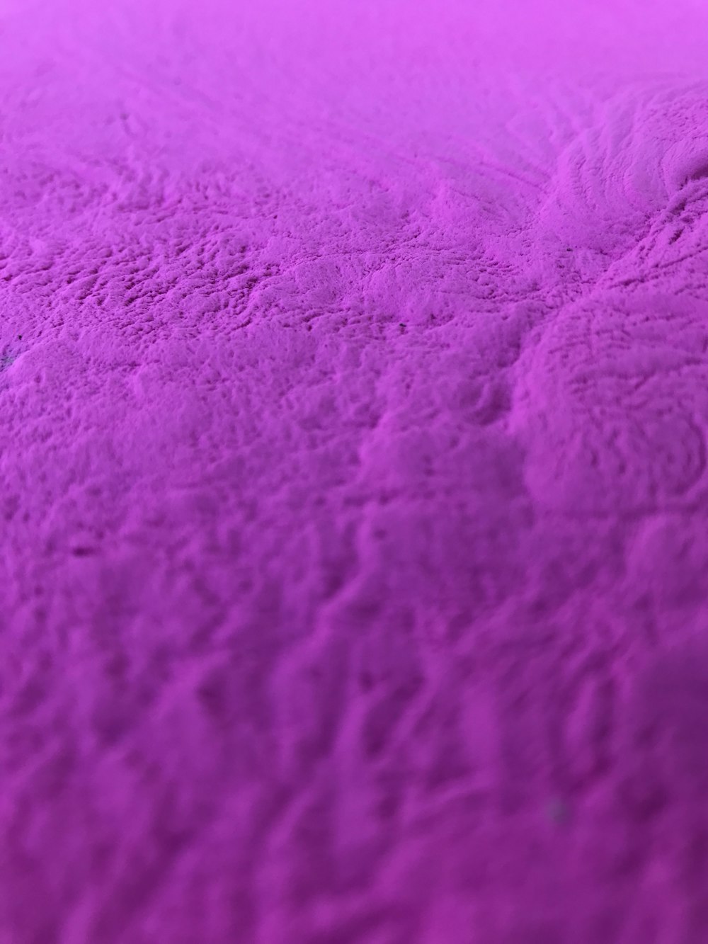 a close up of a bed with a purple blanket