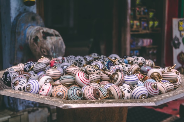 Neatly arranged assortment of cabinet knobs in various shapes and finishes on a white background
