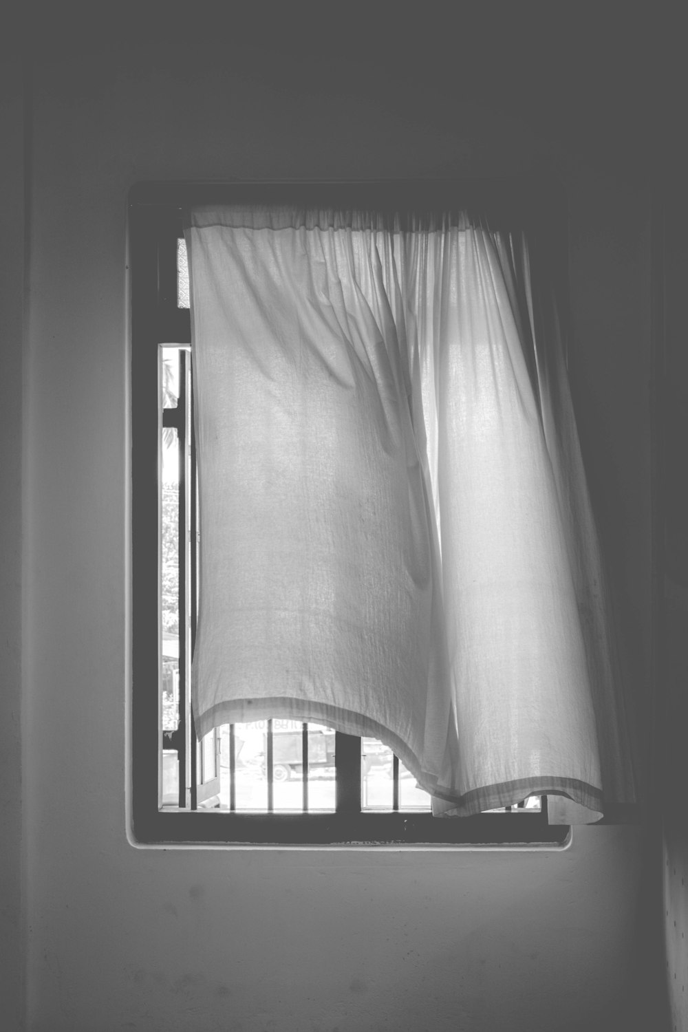 grayscale photo of window curtain