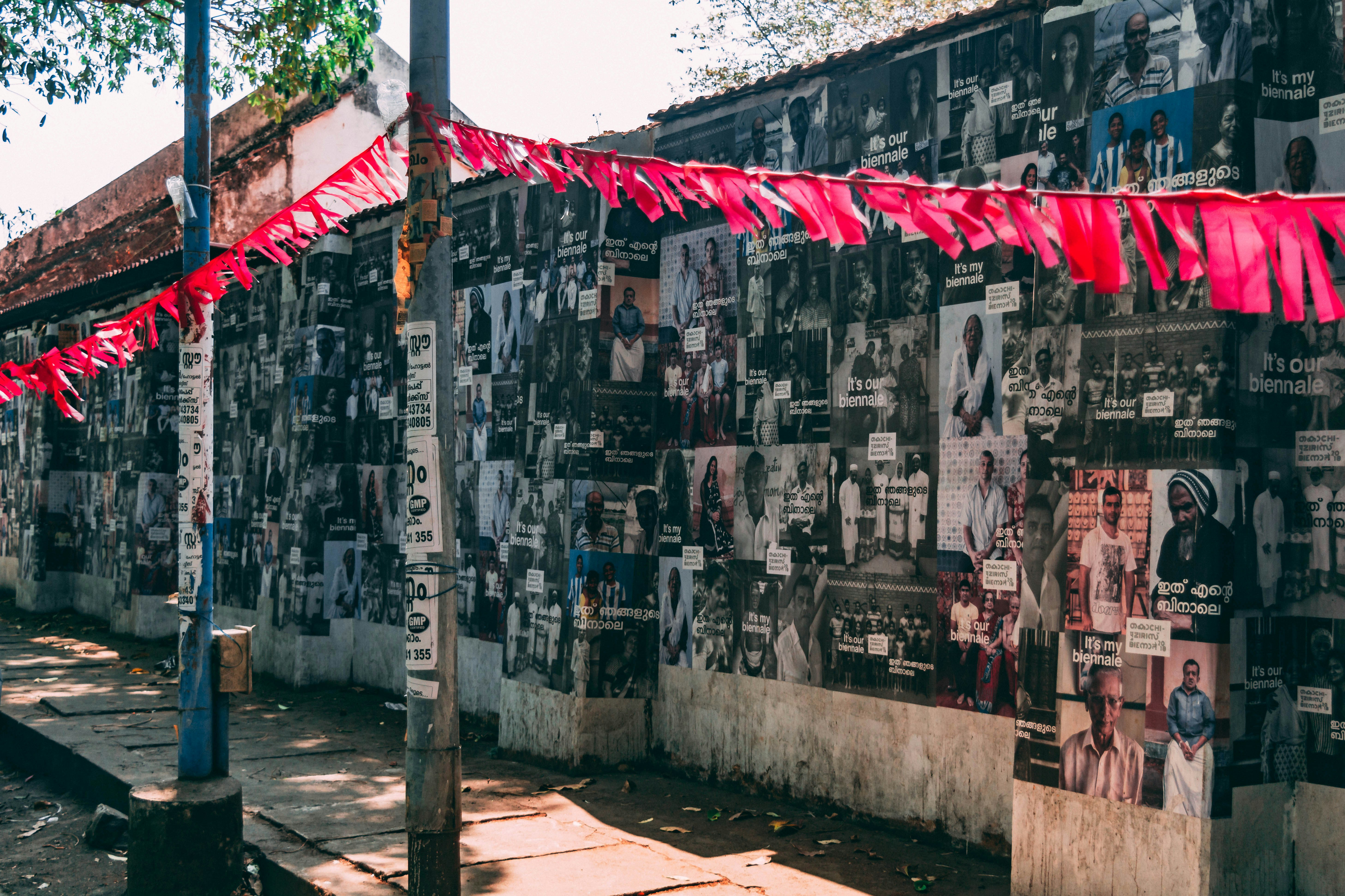 photography of assorted photos on concrete wall during daytime