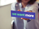 woman holding we want more sign