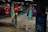 Vivid graffiti art covers multiple concrete pillars in an underground space, featuring a variety of colorful and intricate designs, including faces, abstract shapes, and lettering. The floor is reflective with small puddles, adding to the dynamic and urban atmosphere of the setting.