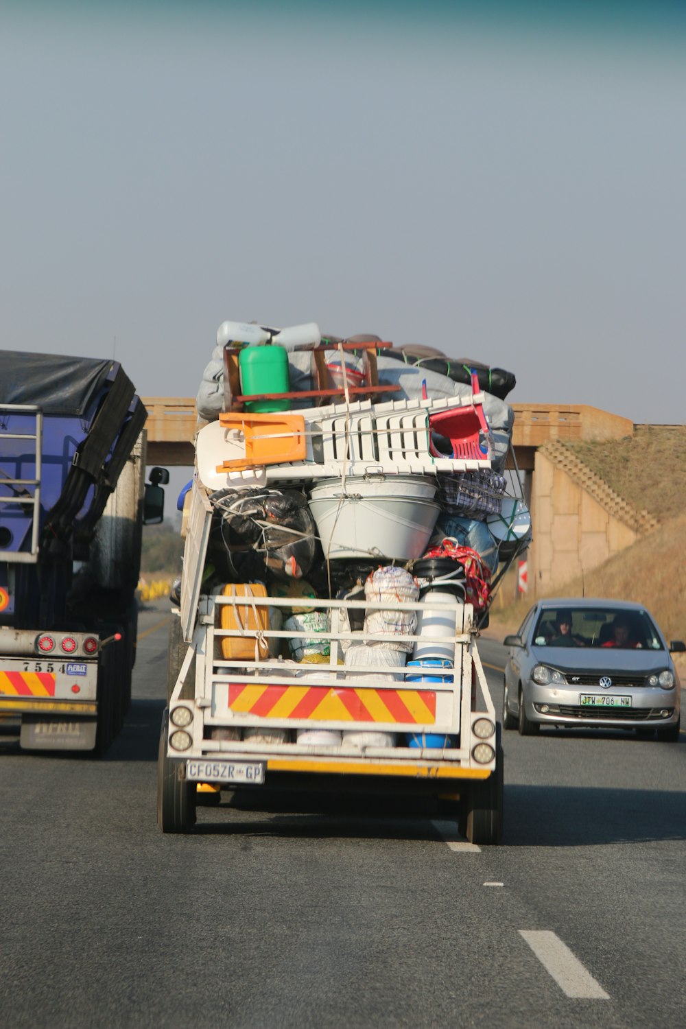 truck carrying plasticware on the road near vehicles during day