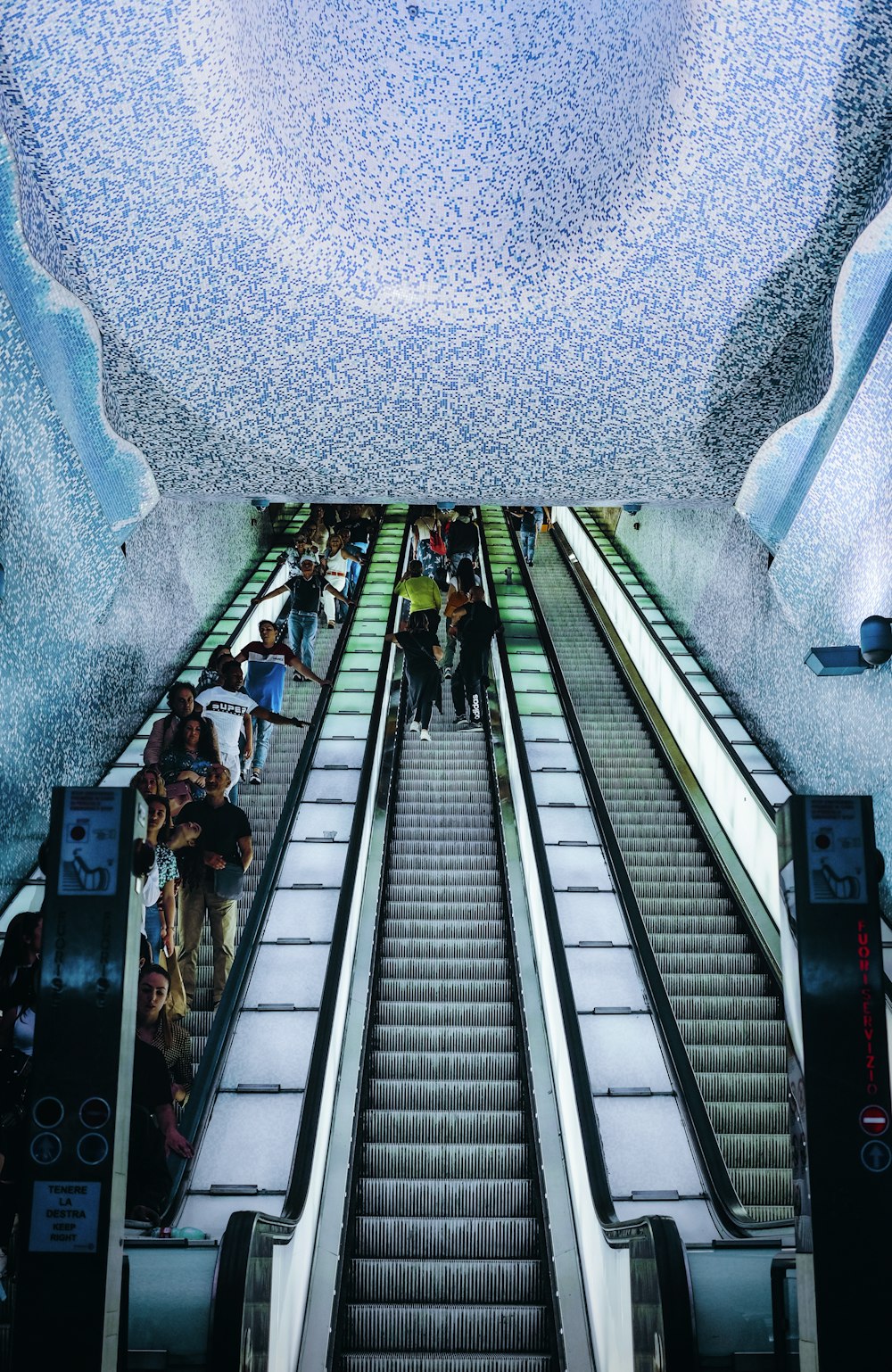 people riding escalator