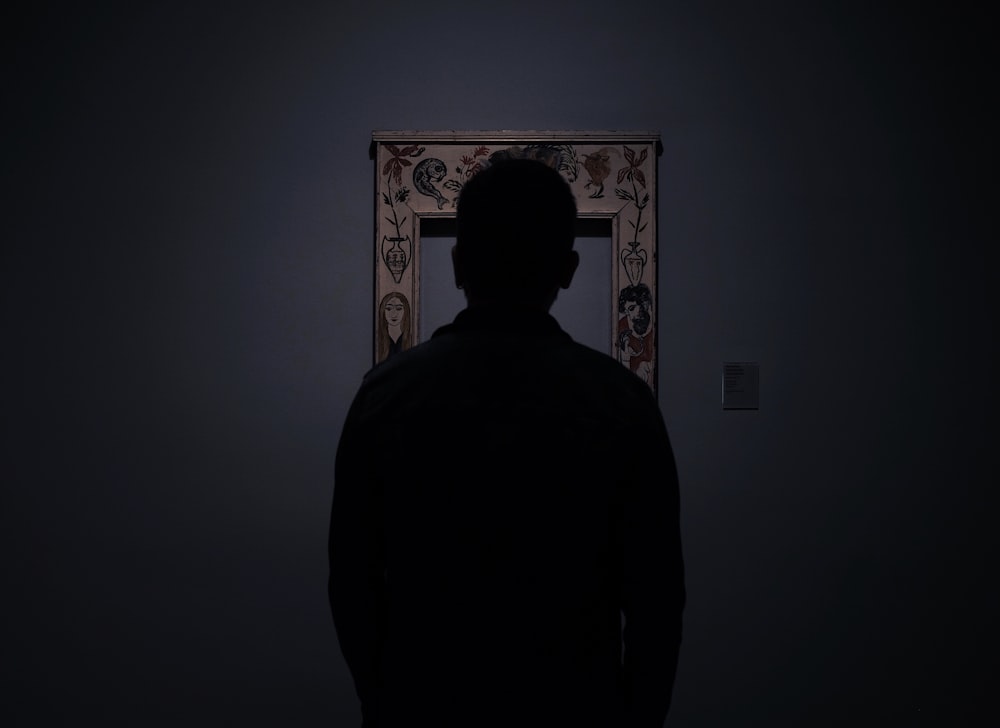 silhouette di persona di fronte a una cornice per foto vuota