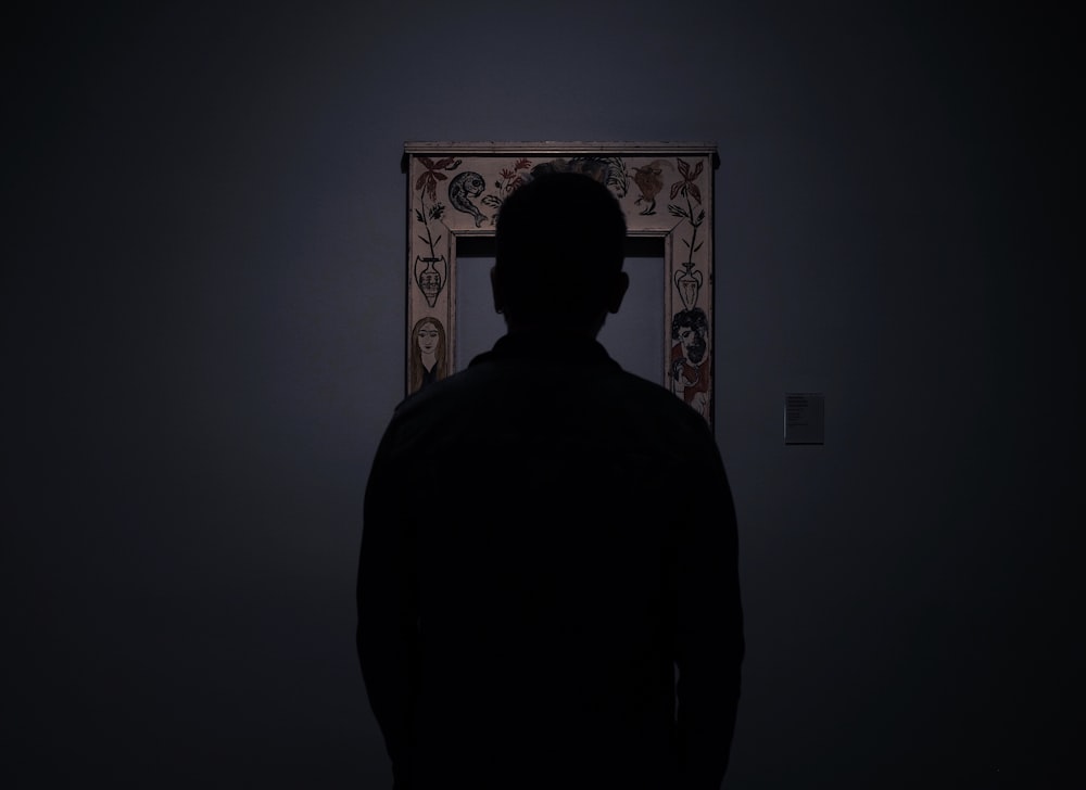 silhouette of person facing an empty photo frame