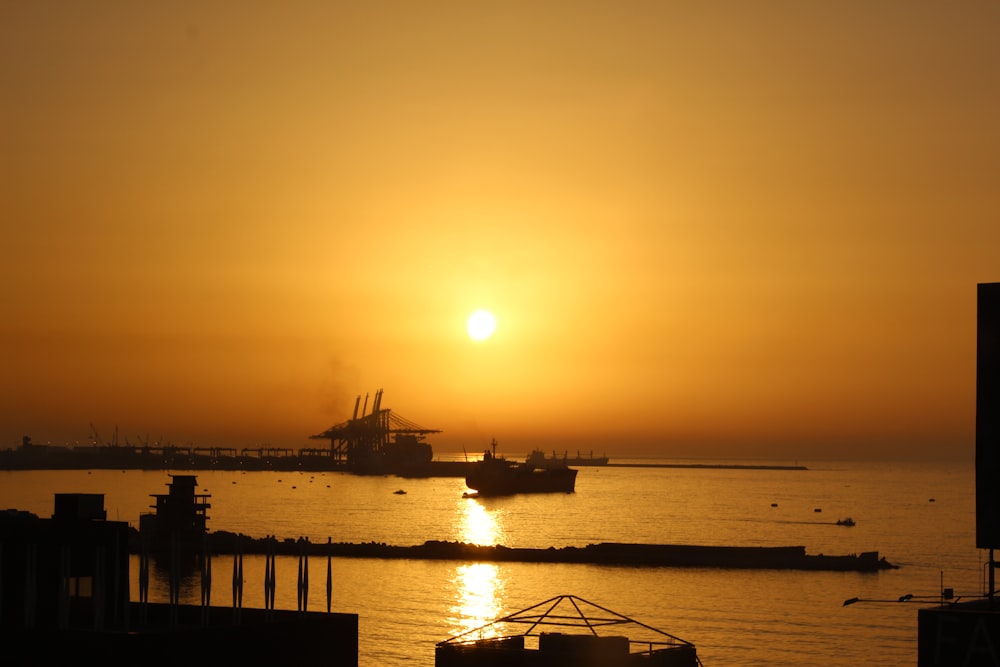 silhouette of boat on water during golden hour