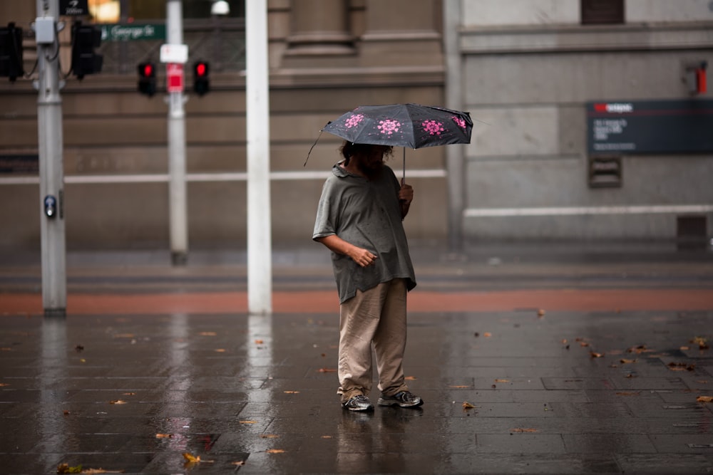 man under black and pink umbrella