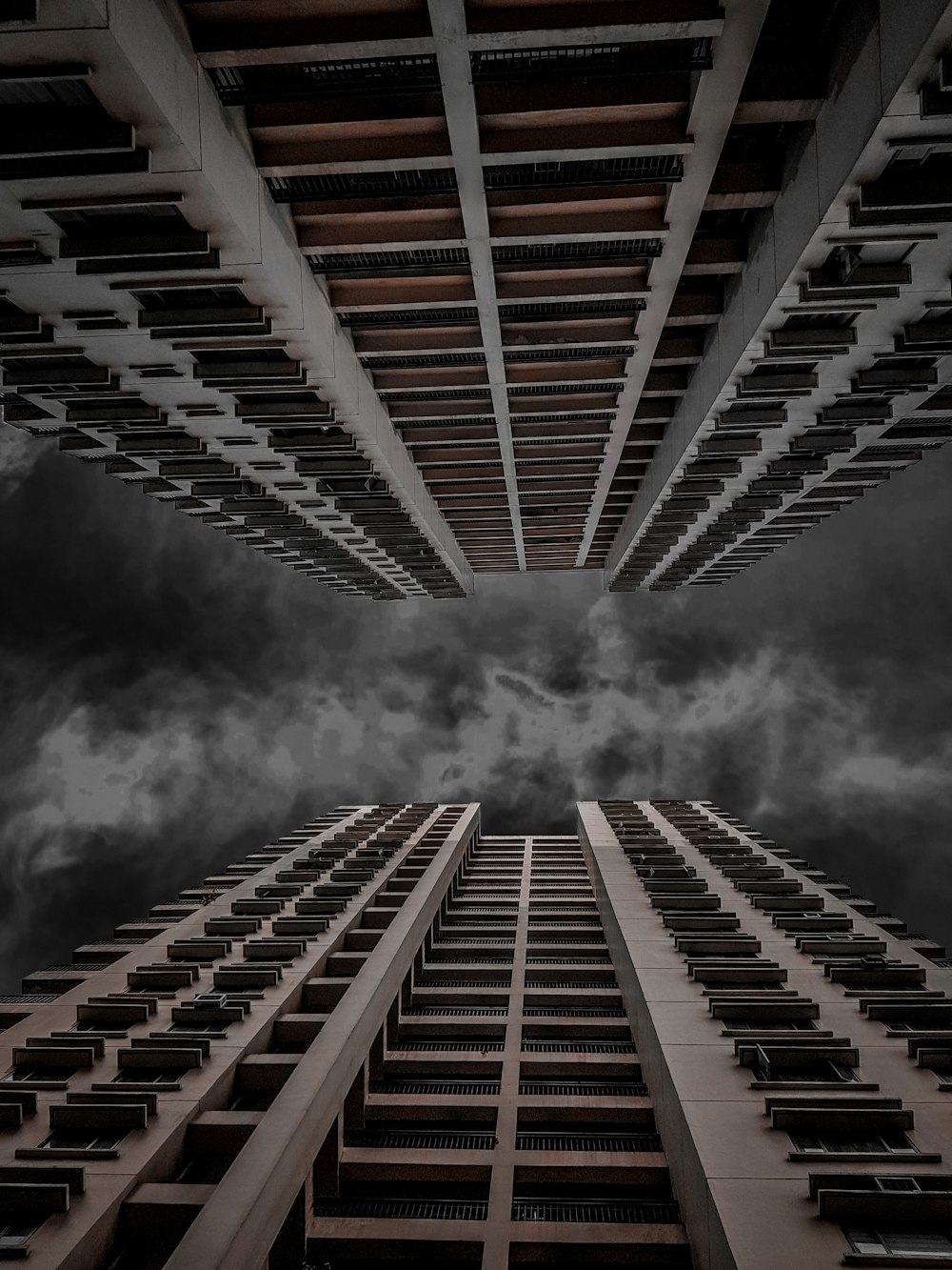 low angle photography of two high rise buildings under cloudy sky