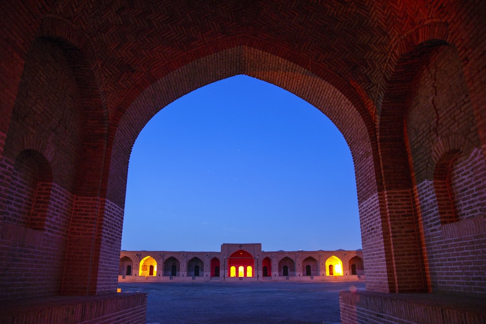 an archway leading into a building with a clock tower in the background