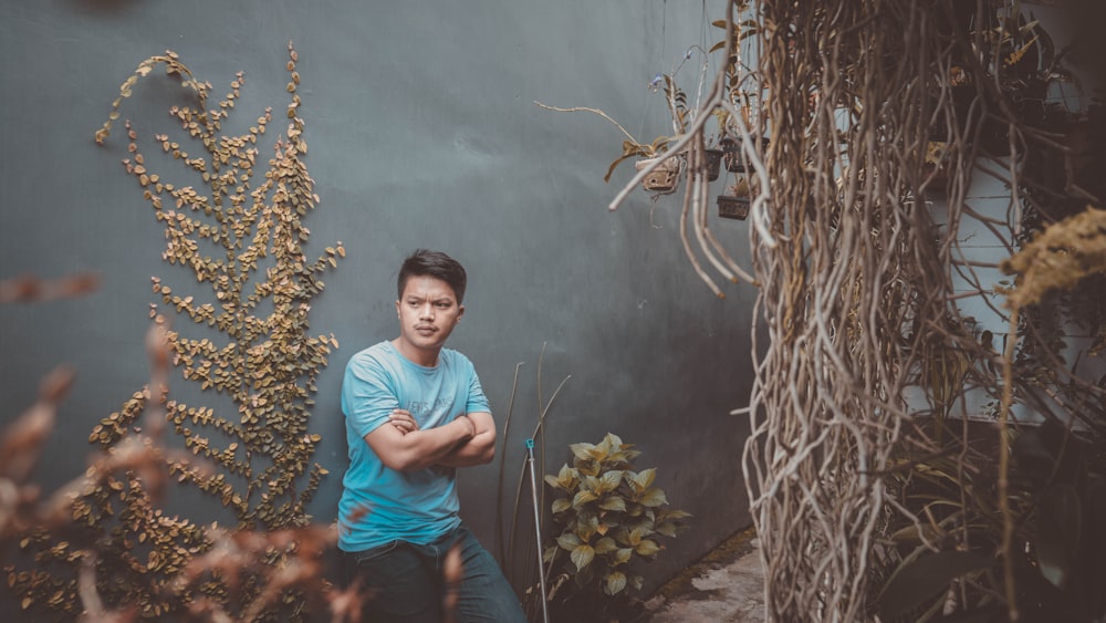 man in blue shirt near plants