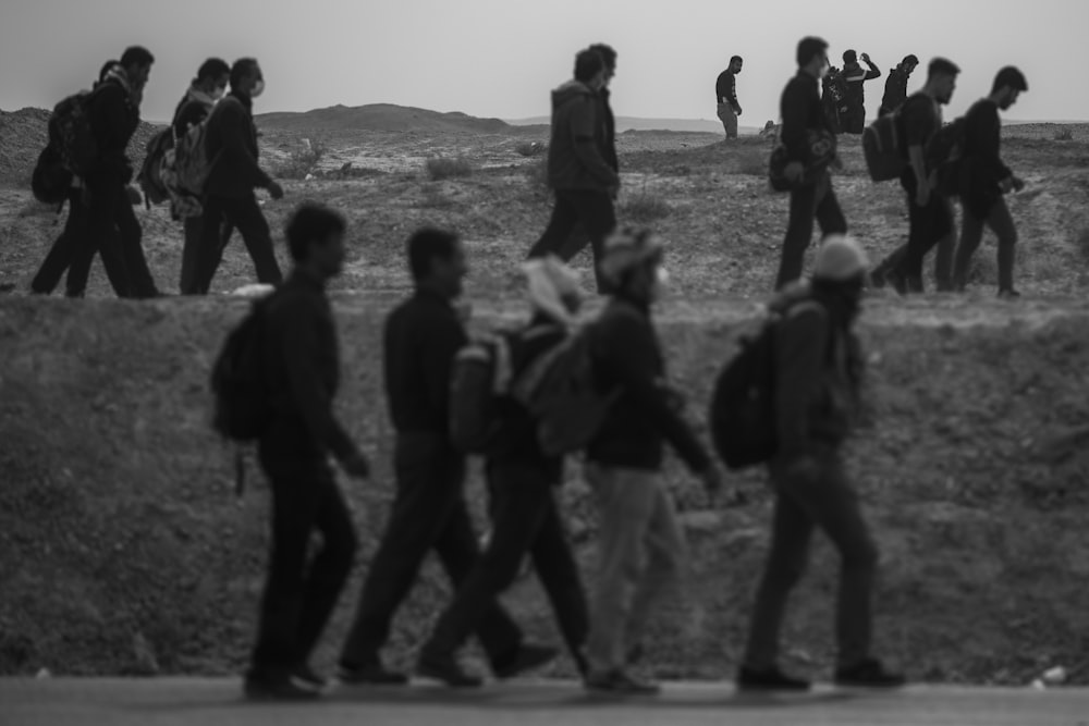 a group of people walking across a field