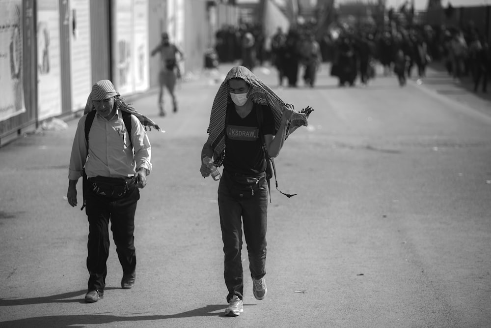 grayscale photo of man walking on street