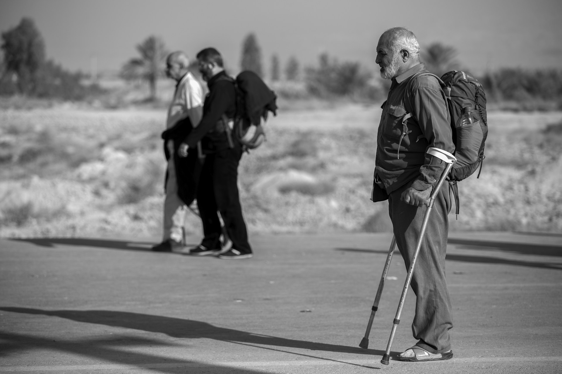 grayscale photo of man with crutches