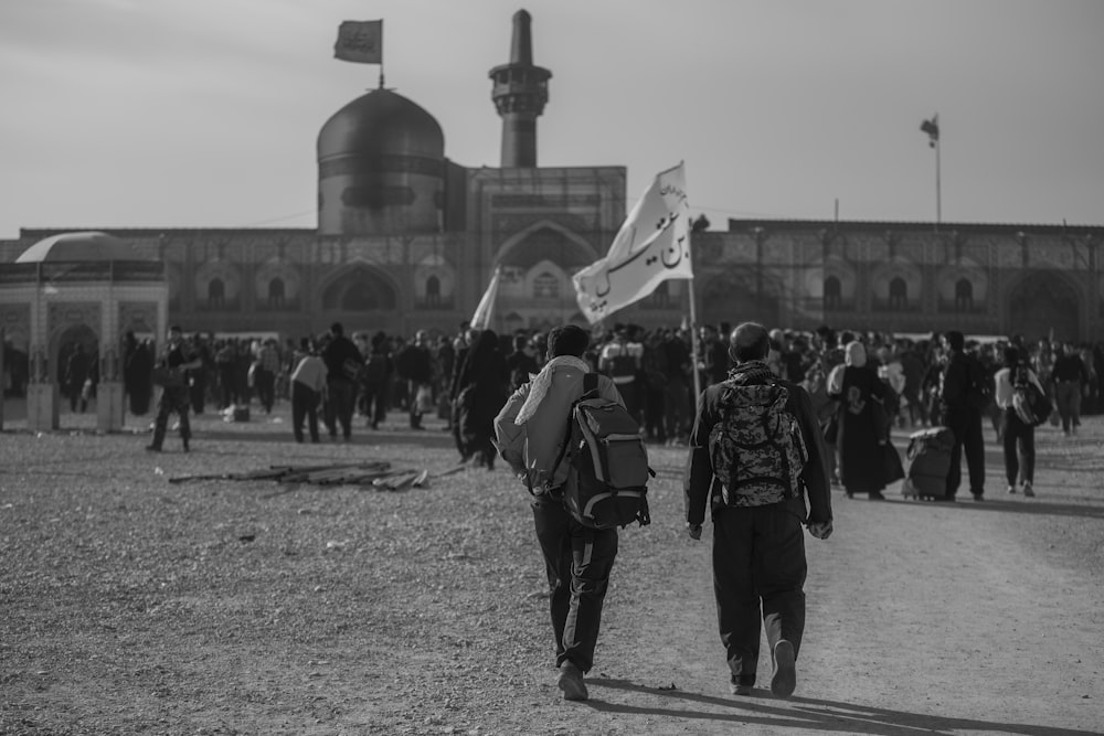 grayscale photo of people near structure