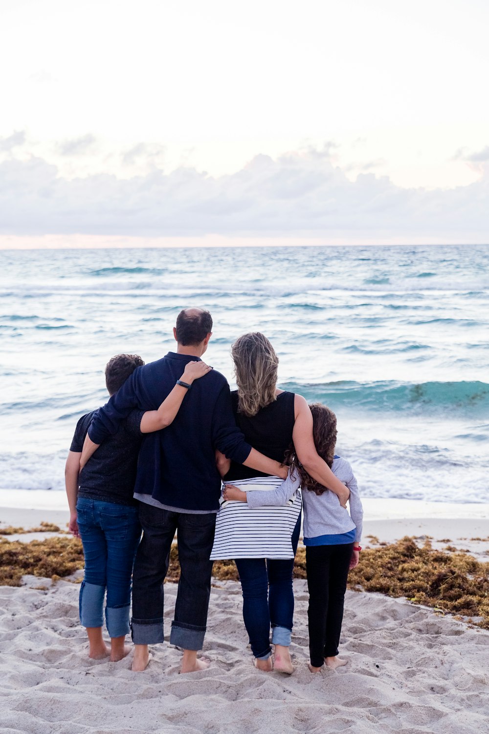 uma família de quatro pessoas em uma praia