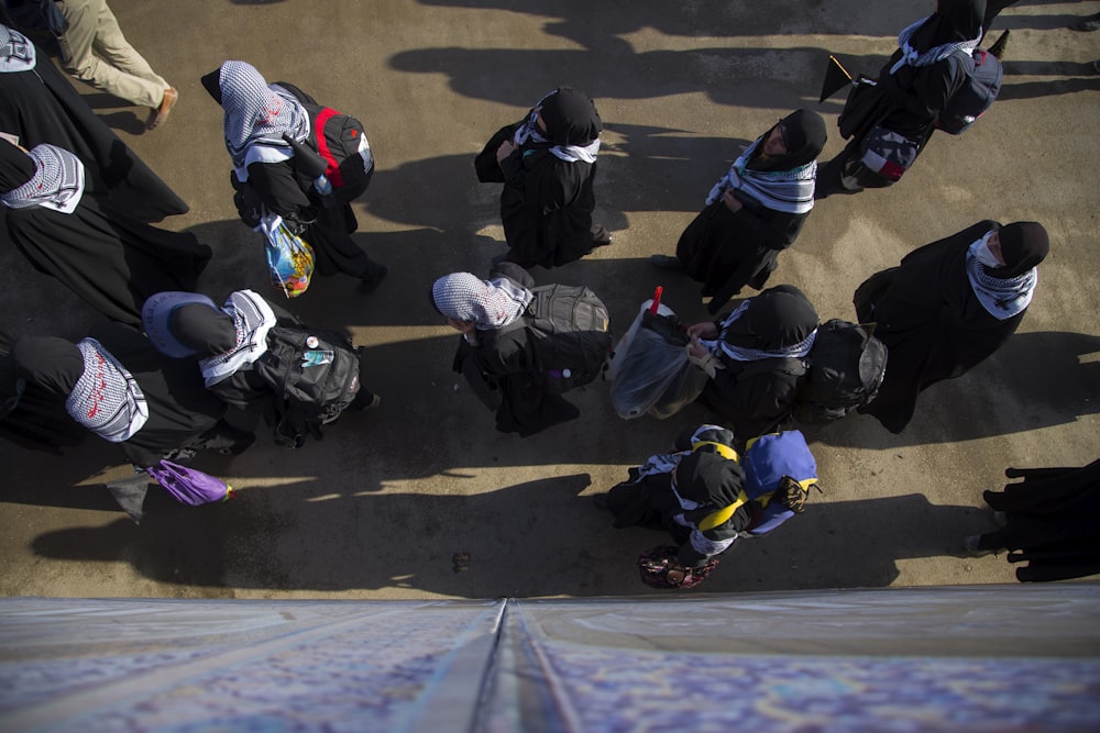 group of people walking beside wall