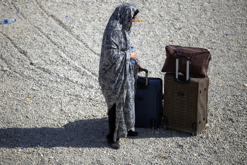 woman standing beside two luggage during daytime
